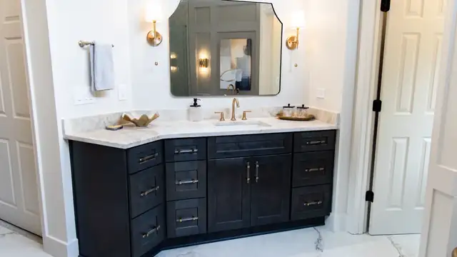 Bathroom with a white freestanding tub under an arched window, marble-look wall tile and a walk-in shower with mosaic niche